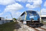 A southbound Magonia Park to Miami Airport Tri-Rail Train arrives into Metrorail Transfer Station behind BL36PH # 822 